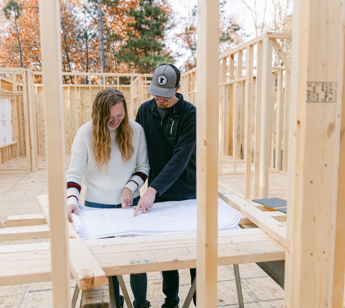 Entrepreneur et cliente relisant les plans sur le chantier